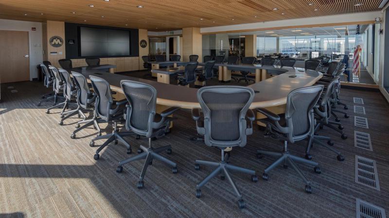 的 Harold Schafer Leadership Center Boardroom features a large monitor at the front of the room with seating for several executives.